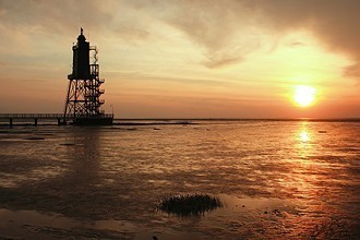 Dorumer Leuchtturm und Watt bei Sonnenuntergang